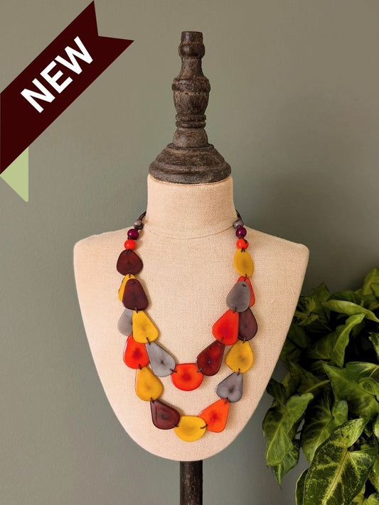 Colorful necklace on a mannequin bust with a 'NEW' label against a plain background