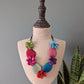 Colorful floral necklace on a mannequin bust with a gray background